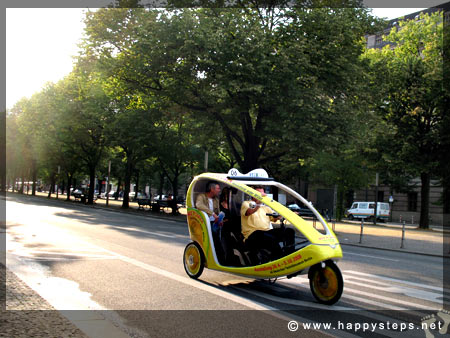 Photo of velotaxi with tourists cruising along Unter Den Linden Avenue, Berlin