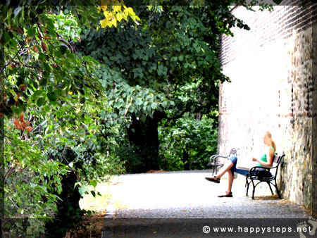 A lady reading a book by the castle wall at Vysehrad Castle, Prague