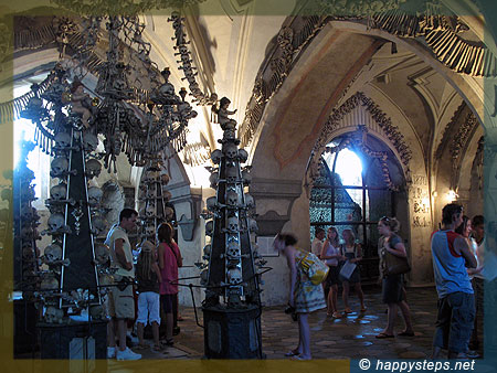 A lady tourist inspecting the intricate details of the skull decors at the Kutna Hora Ossuary in Czech Republic